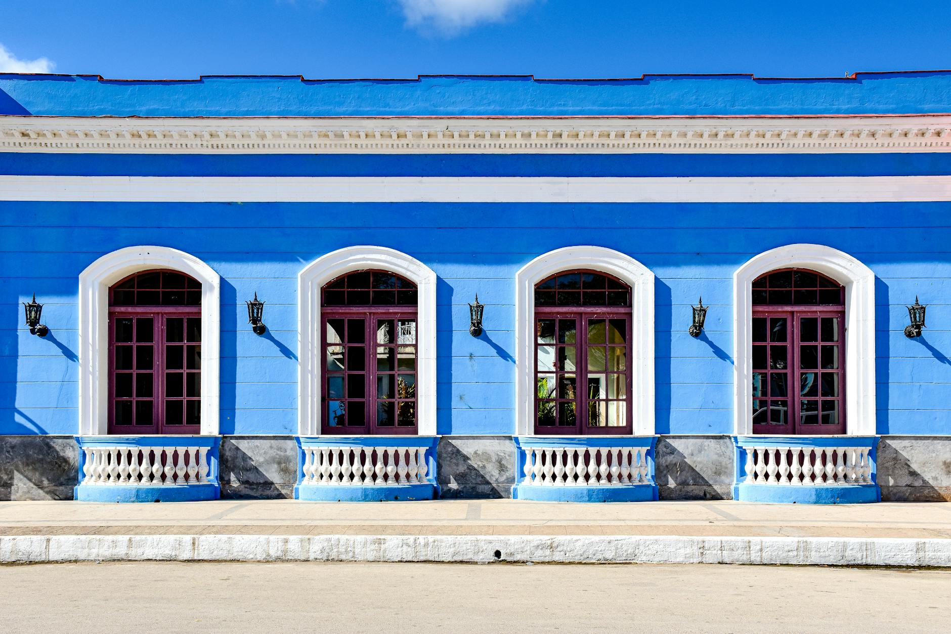 Sunlit colonial blue building façade in Remedios, Villa Clara, Cuba, showcasing classic architecture.