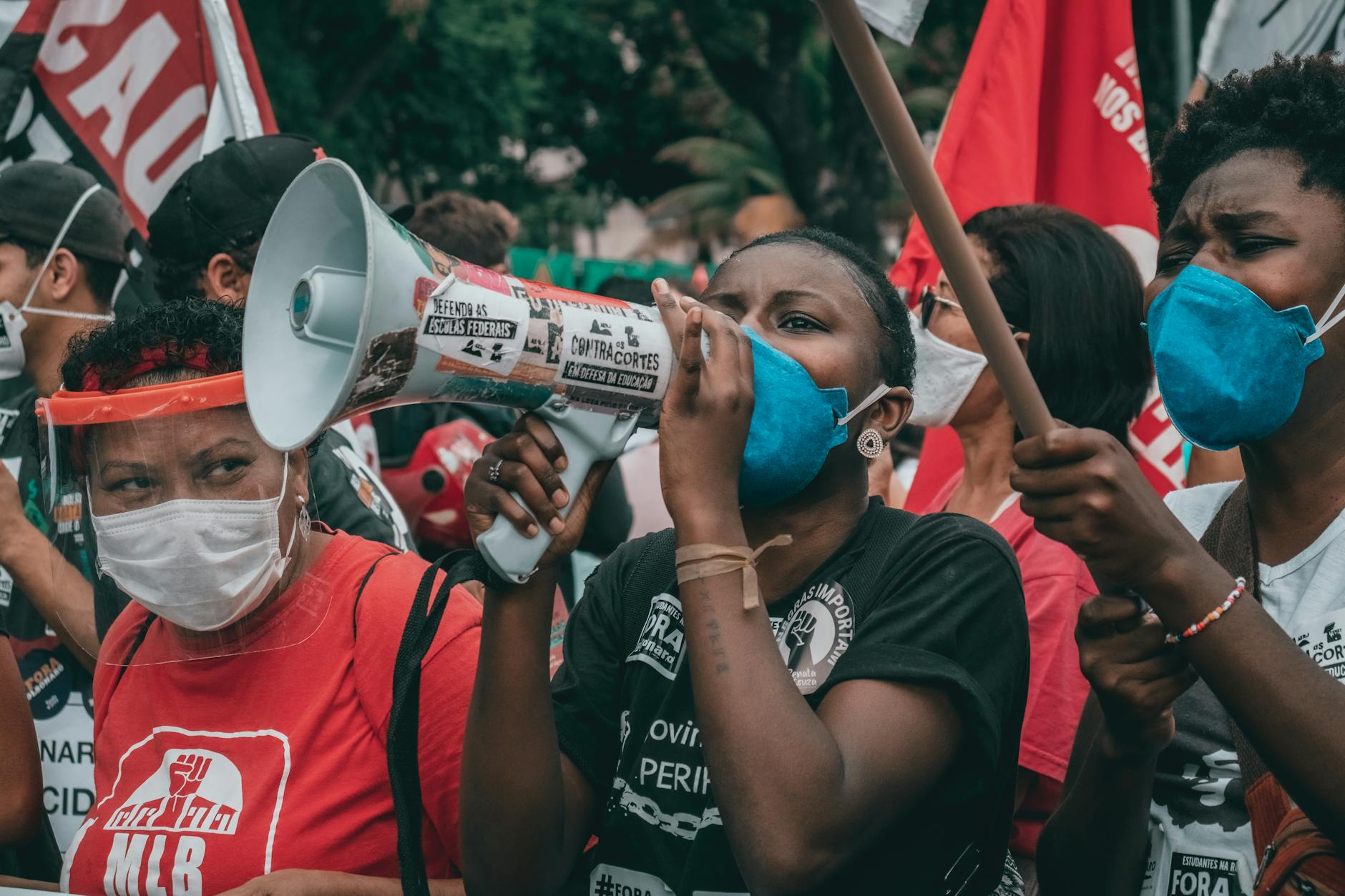 Protesters in masks advocate for rights in Rio de Janeiro amid political unrest.