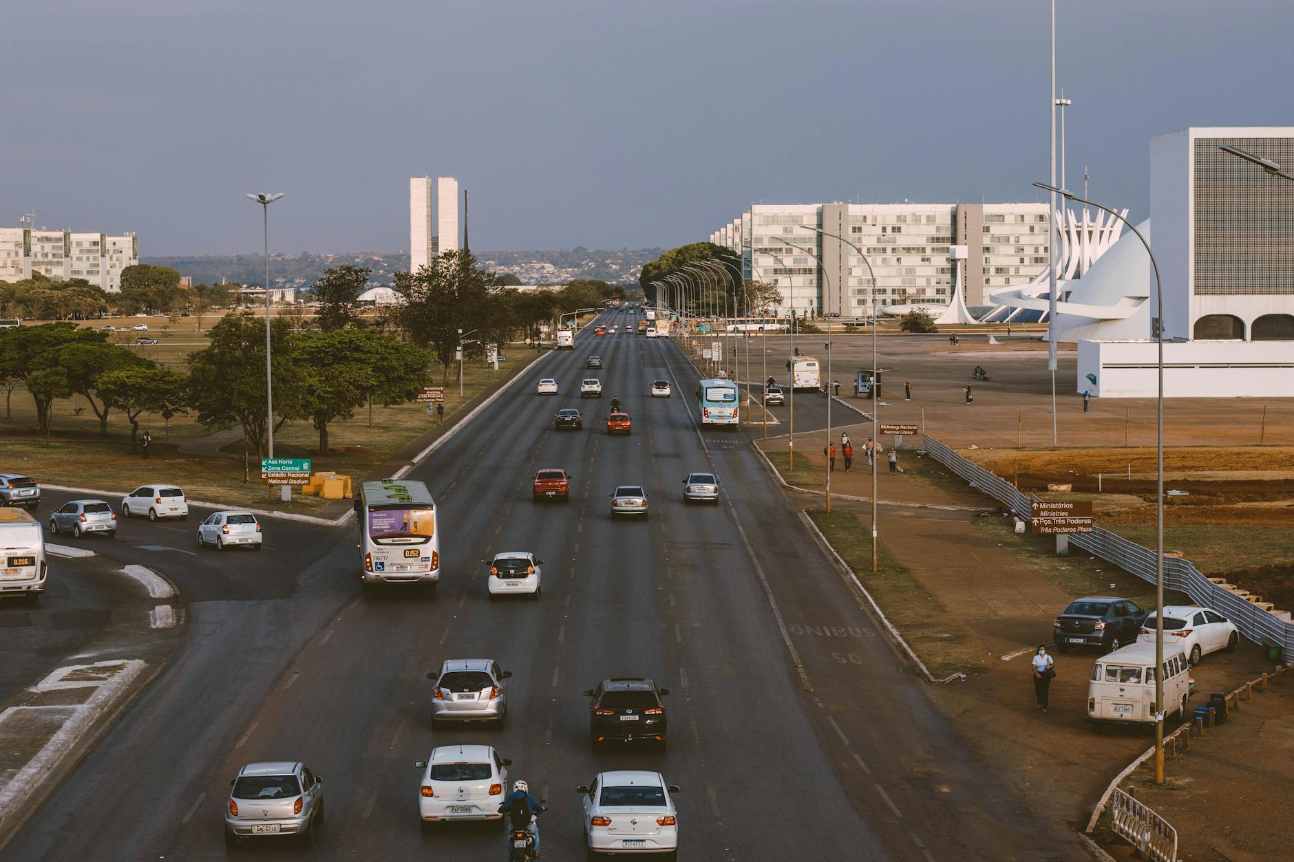 Aerial view of Brasília's urban traffic with prominent government buildings and a bustling road.