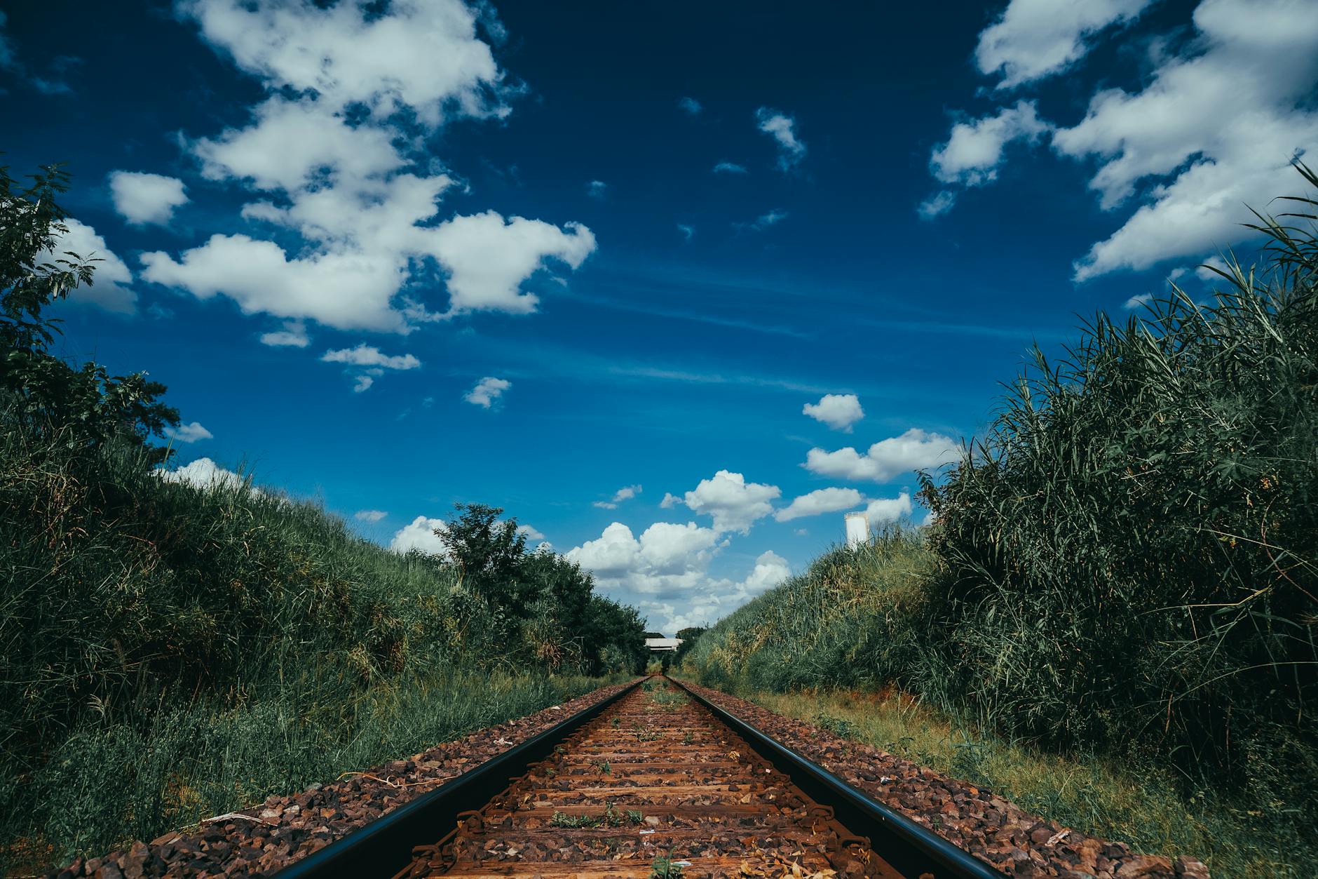 Explore the tranquil railway tracks under a vibrant blue sky in Mirassol, SP, Brazil.