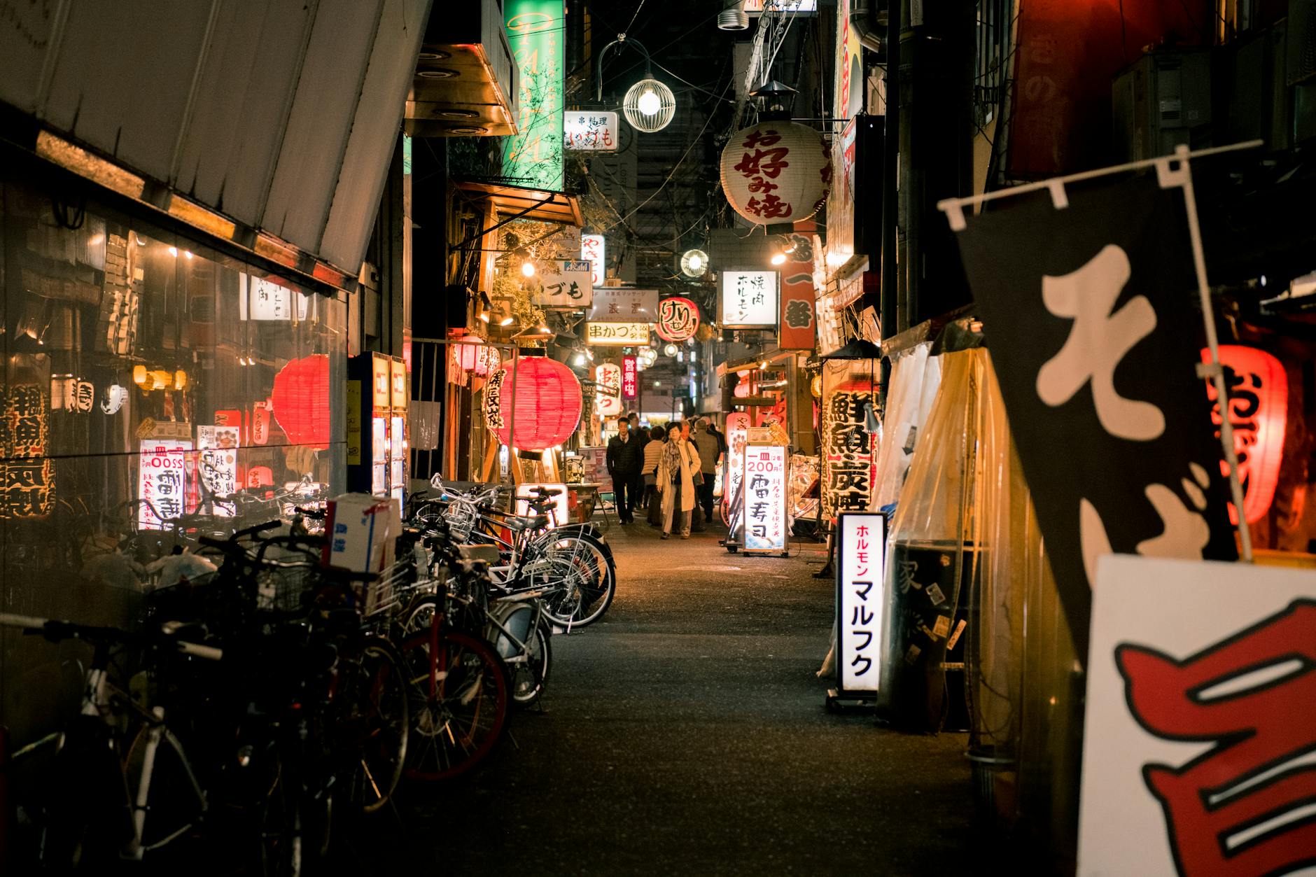 Explore the bustling nightlife in Dotonbori, Osaka with illuminated lanterns, shops, and people.