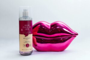 Stylish pink lip decor and body splash bottle perfect for a modern lifestyle shot.