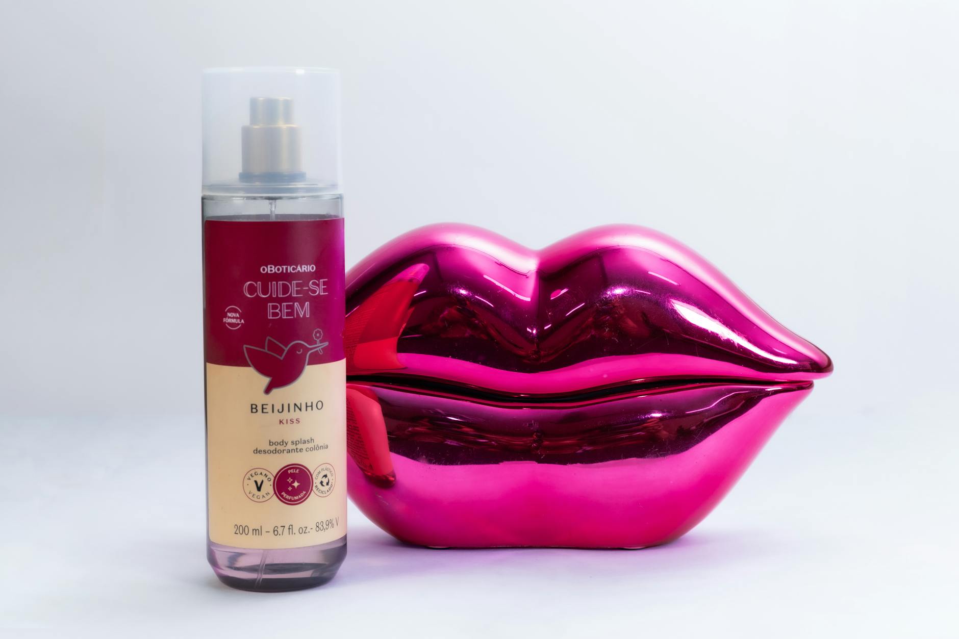 Stylish pink lip decor and body splash bottle perfect for a modern lifestyle shot.
