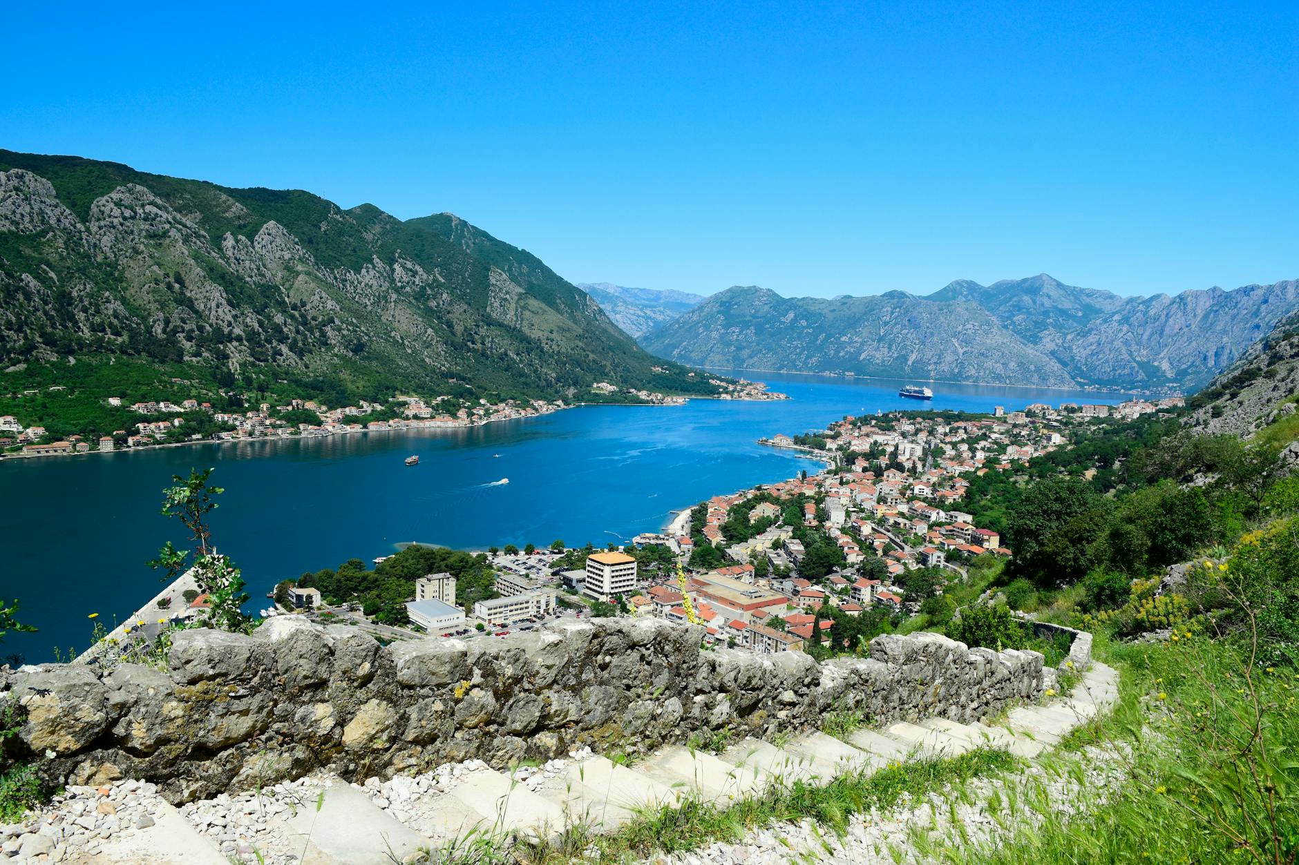 A stunning aerial view of Kotor, Montenegro showcasing the bay, cruise ship, and mountains.