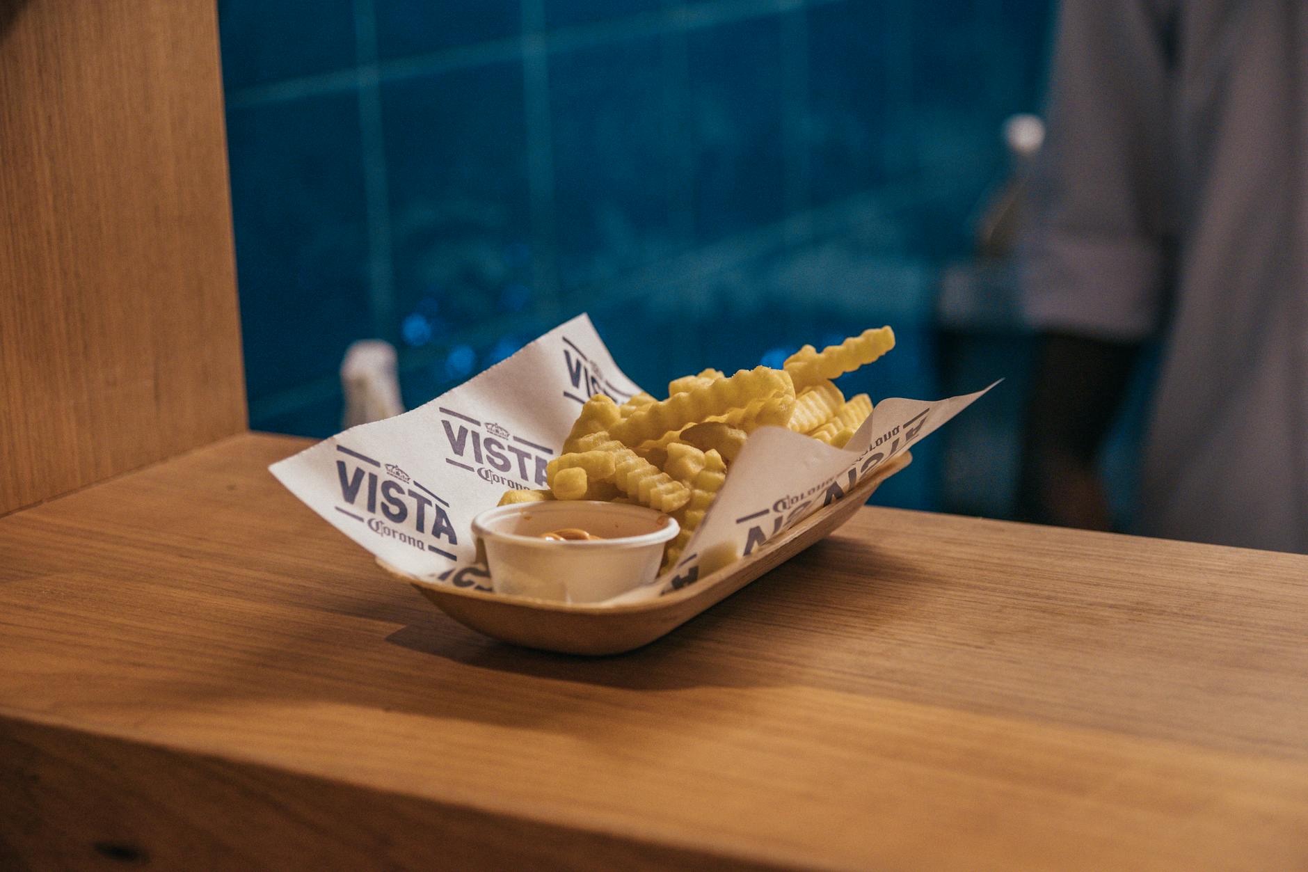 Delicious crispy french fries served with dip on a wooden surface at a São Paulo restaurant.