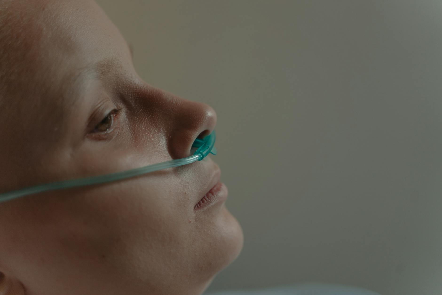 Profile of a woman with a nasal cannula in a serene hospital setting.