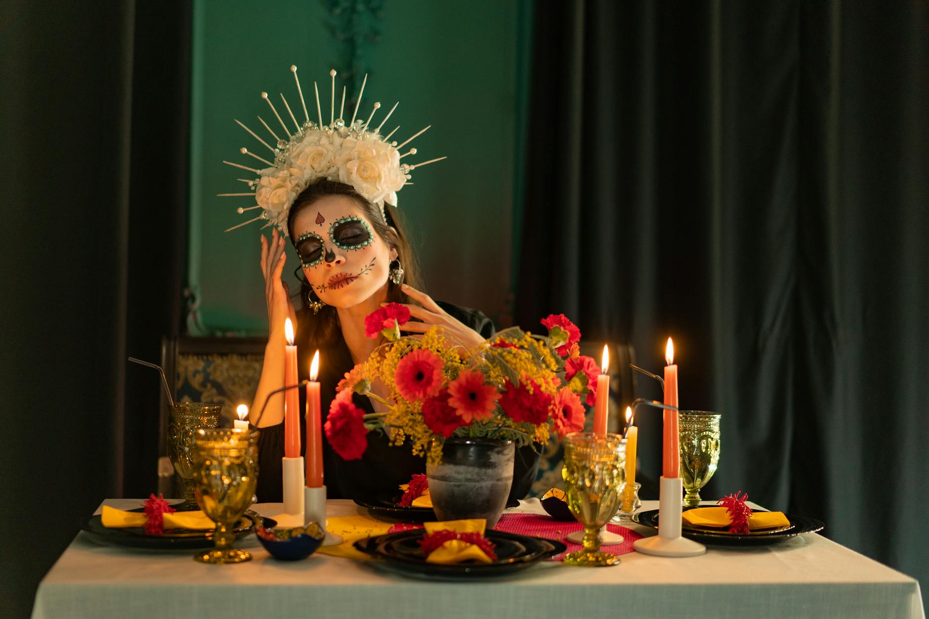 Elegant Dia de los Muertos scene featuring a woman with traditional makeup and vibrant table setting.