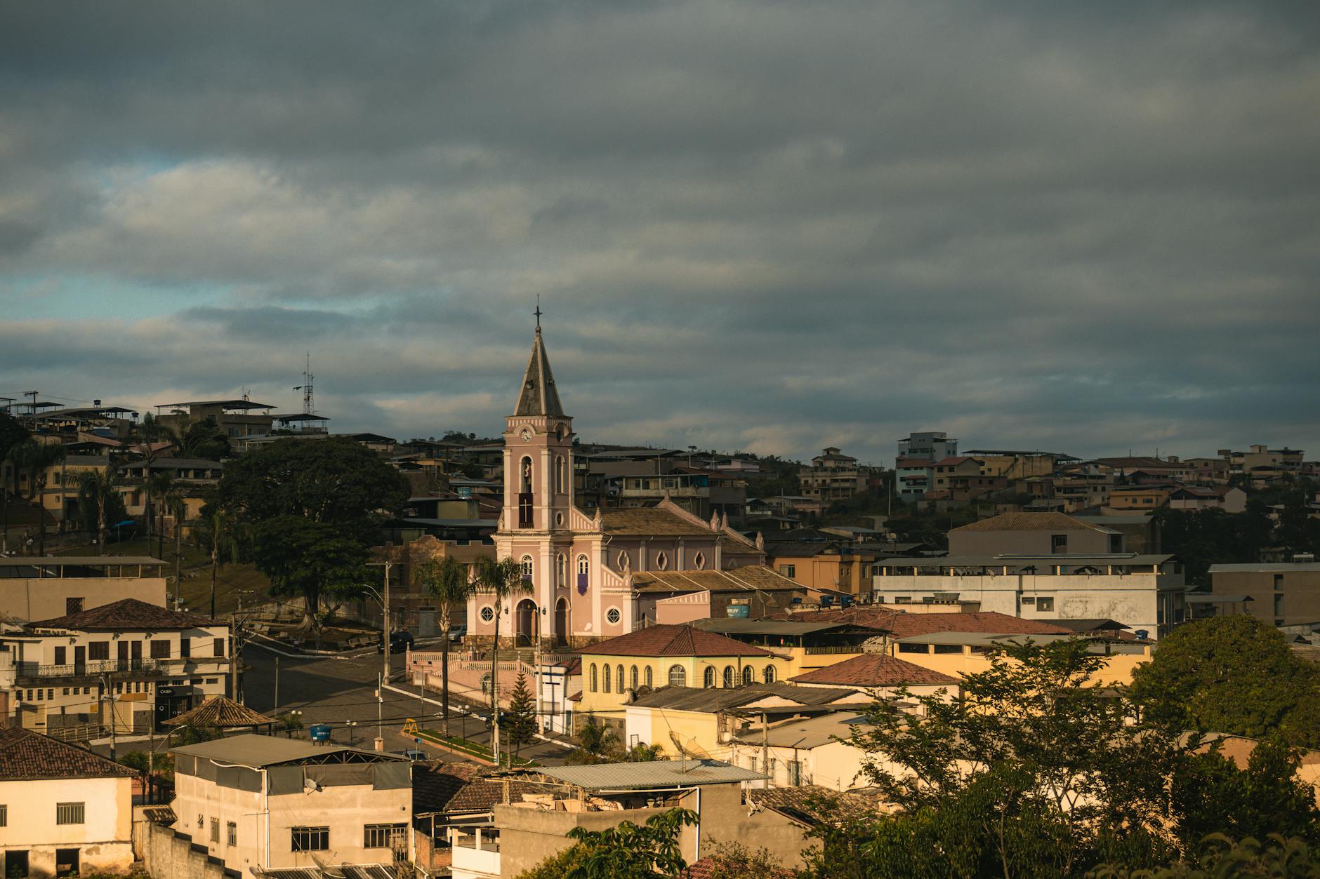 Scenic view of a traditional church in Dores de Campos, Brazil, under cloudy skies.