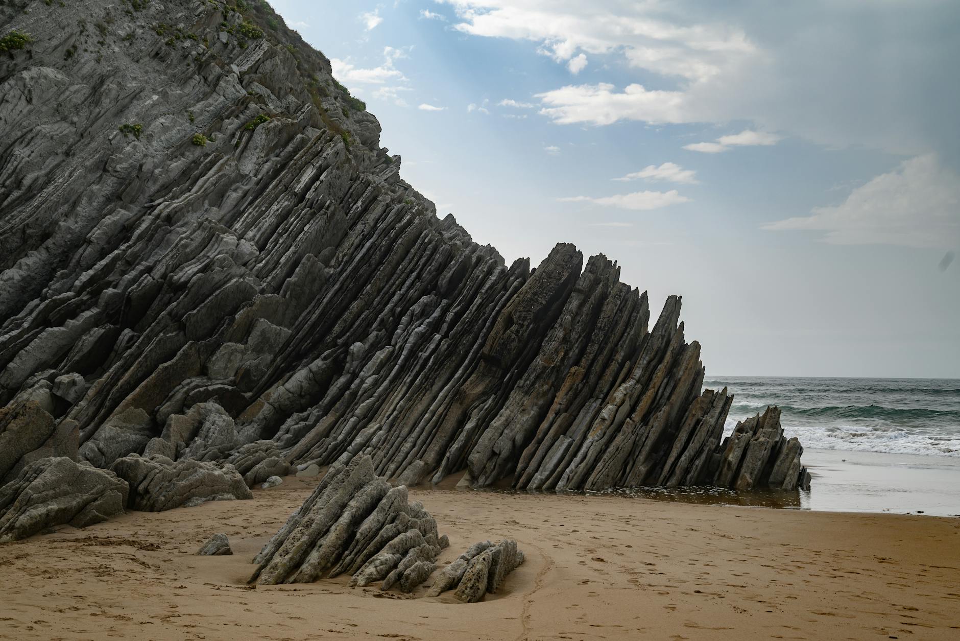 Unique rock formations on a sandy beach in País Vasco, Spain with ocean view.